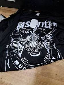 lot 2065 image: Black T-Shirt with White Guitar and Decorative Design Print. Features Musical Theme with Ornate Acoustic Guitar and Artistic Elements. Made in China, size XX-Large Plus.