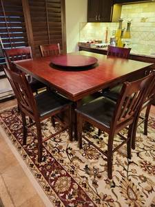 lot 1014 image: High top dining table 36 x 48 x 48 with 6 chairs  48, chair height 24 in with lazy Susan turntable, few scrathes and one chair needs repair