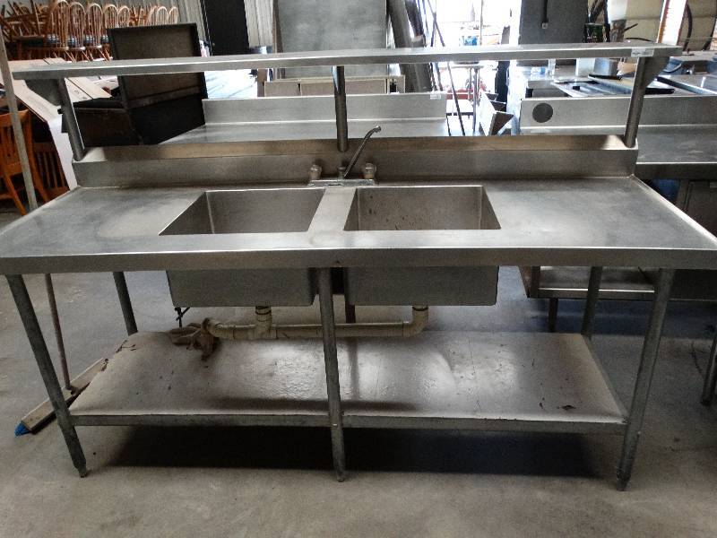 lot 2556 image: 7W x 30D x 36T Stainless steel sink with 2 sinks. Has one full lower shelf and shelf above.