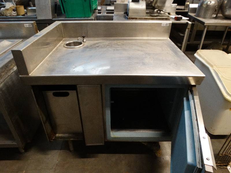 lot 2573 image: 42W x 32D x 36T stainless steel table with backsplash on the left and back. 19W x 18T cooler in lower right of unit and trash can in lower left. Water tap and 5.5 diameter drain basin.