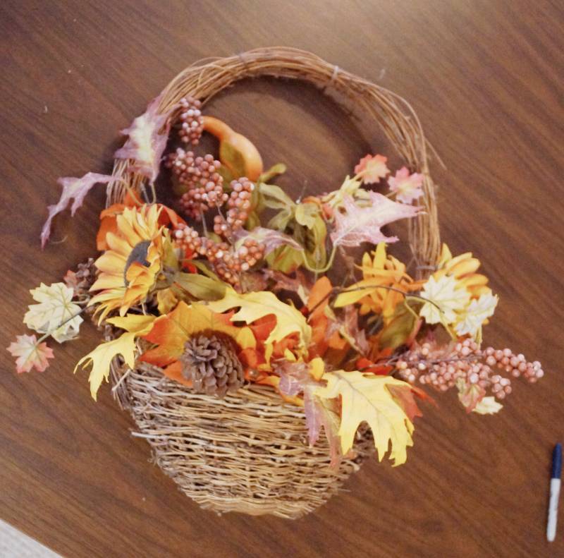 lot 2697 image: Neat Woven Wicker Decorative Basket that hangs against the wall. Includes Fall Flowers Ready to hang