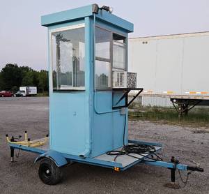 lot 65 image: Guard or Ticket Booth or Hunting Shack - Par-Kut Mobile Security Booth Trailer w Leveling Jacks, Approx 7x11x8ft, 50ft Electric Cord to Plug into 120v Power, Main Circuit Breaker Breaker w Lights (Outside & Inside) & Outlets, Heat & AC