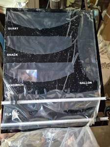 lot 20150 image: Food Bag Organizer with Foil and Plastic Wrap Organizer, Kitchen Drawer Organizer, Wrap Dispenser with Cutter, for Gallon, Quart, Sandwich, Snack Bags and 12 Roll (Black) - Retail $44