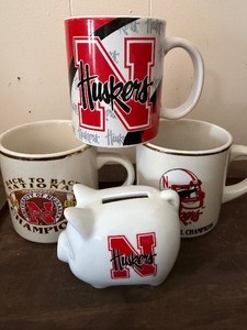 lot 508 image: Collegiate Sports Memorabilia - Nebraska Coffee Mugs and Piggy Bank