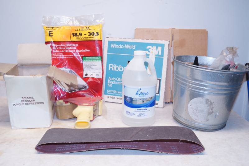 lot 1049 image: Lot of Auto Glass Repair Items, Bucket of Hardware, Filter Bags, Tongue Depressors and tape gun, sanding belt & more