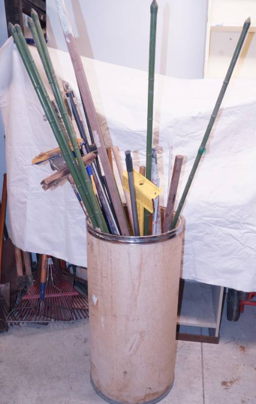 lot 1083 image: Paper Storage Barrel w contents - green yard stakes, brooms, mops, etc �