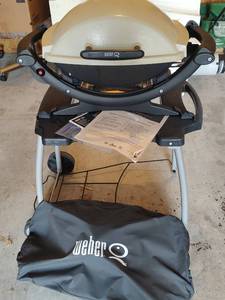 lot 9 image: Weber Q Series LP Portable Gas Grill on Wheels. Owners Manual Included and Protective Cover