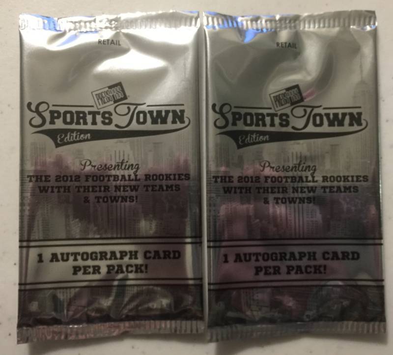lot 1080 image: Two Sealed 2012 Press Pass Sportstown Football Card Packs with Two Guaranteed Rookie Autographs Russell Wilson Luck