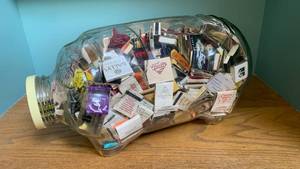 lot 1283 image: 20x10 glass piggy bank filled with match books from various establishments