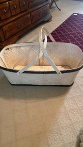 lot 1333 image: Antique bassinet approximately 78 years old, white with black trim, woven split wood with handles, 12x31.5x18.75, some wear and tear due to age