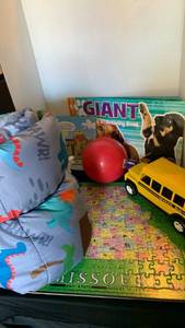 lot 3017 image: Sleeping bag, puzzle, coloring books, school bus and ball