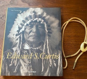 lot 274 image: Book - Edward S. Curtis by Hans Christian Adam-Featuring Photos of Native Americans and a Bolo Tie w Arrow