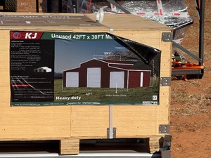 lot 1388D image: Unused K4230G 42 x 30 Triple Garage Metal Building  Red Brown in color, 26 gauge sheet metal, 3 Roll up doors and Includes 1 walk through door. 13 ft height