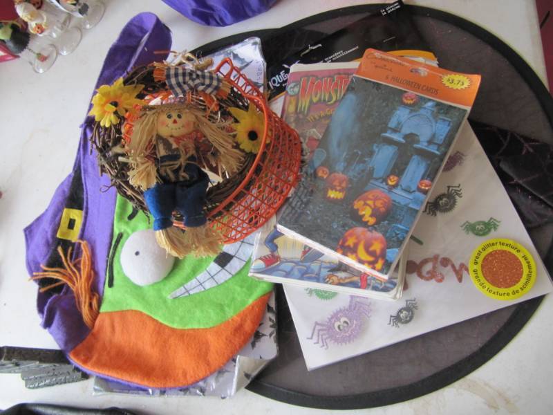 lot 340 image: Halloween wire pumpkin, ribbon, VHS, 2 new witchs hats, 2 new Halloween decorations, and trick or treat bag