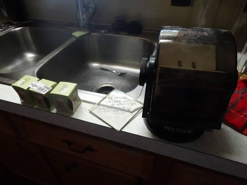 lot 1946 image: 3 Small candles, rolodex and a wall decor.