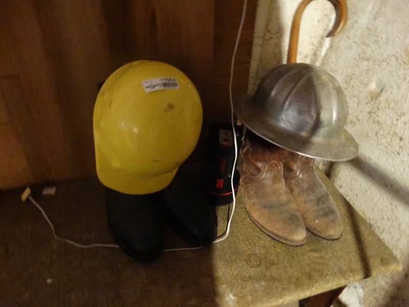 lot 17053 image: Lot with 2 hard hats 2 pair of mens boots and a flashlight.
