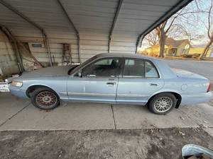lot 1165 image: 1999 MERCURY GRAND MARQUIS GS, 4.0 LTR ENGINE, 197,460 MILES, NEEDS BATTERY, GUAGES NOT WORKING, RUNNING WHEN PARKED