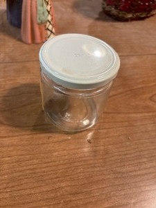 lot 27219 image: Small Glass Lidded Jar with Two Foreign Coins