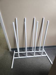 lot 413 image: White metal drying rack  Maybe for tall boots  There are 2 racks, one is missing end pieces.  could use the metal rods for other purposes