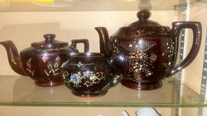 lot 55994 image: The image features a vintage trio of Japanese brown-glazed Moriage teapots.