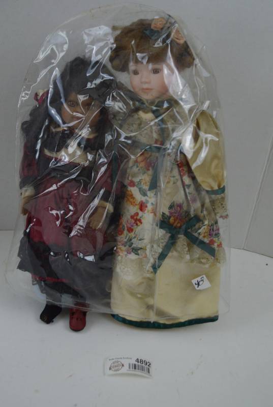 lot 4892 image: 2 Porcelain Dolls with Plastic Protector (One Missing Shoe)