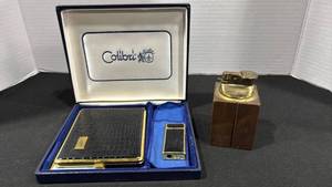 lot 1080 image: Colibri Gold Tone Lighter with Box and Wood Base Brass Lighter