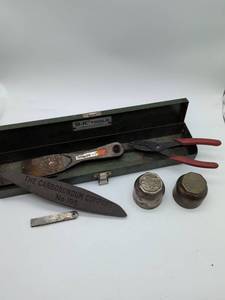 lot 16824 image: Vintage Ford hub grease caps, S-K Box, Carborundum Stone, 4 H knife, pliers in this misc lot.
