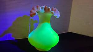 lot 9 image: Fenton UV reactive ruffled top vase painted with a Burmese treatment