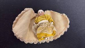 lot 73 image: Antique circa 1909 bisque baby doll and blanket with one arm broken