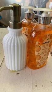 lot 41686 image: Fluted Milk Glass Soap Dispenser with Brass Pump and two hand soaps.