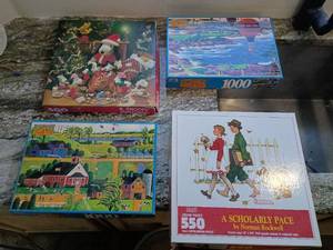 lot 14 image: Norman Rockwell Puzzle Collection Set 2 Hometown 1000 piece puzzle ����1 Snoopy Christmas 500 pieces Unknown if full puzzles