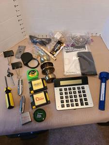 lot 7019 image: Calculators, doorknob, small levels, measuring tapes, magnifying glass, more