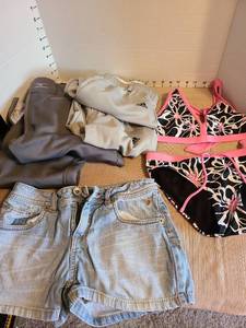 lot 7092 image: Girls swimsuit, denim shorts, Adidas and Mizuno athletic pants, size 14.