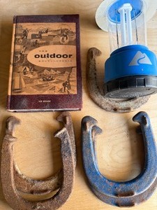 lot 12 image: Outdoor Book (1957), Horseshoes (7) and Lantern