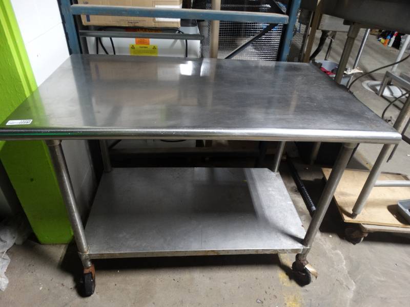 lot 14208 image: Stainless steel table on wheels 4ft long 30 wide 35 tall.