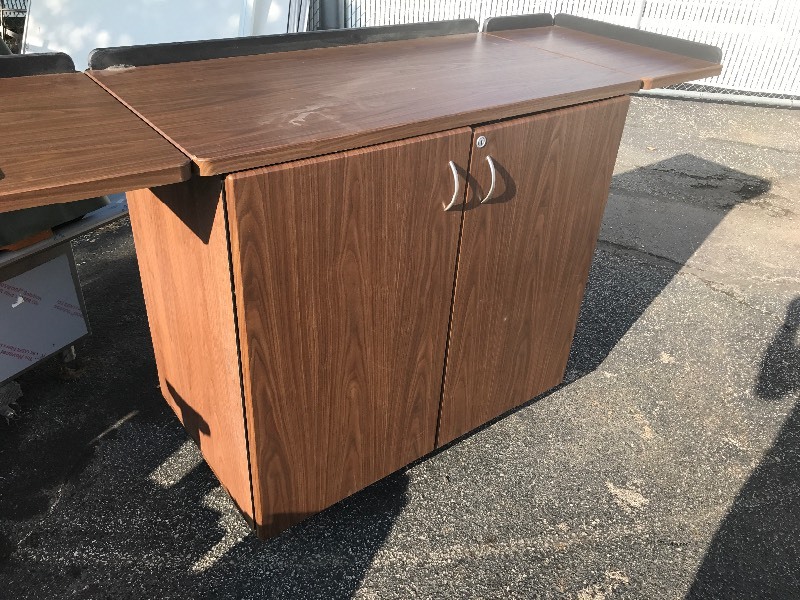 lot 807 image: Another roll around cabinet with fold out arms and locks on casters as pictured