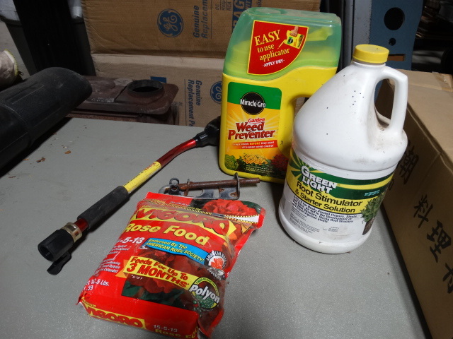 lot 6144 image: Lot with a hat, weed preventer, Green light root stimulater, vigoro 18 water sprayer, vigoro rose food.