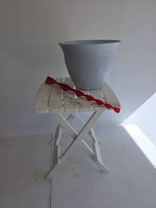 lot 416 image: 12in White Embossed Plastic Planter, Folding Table, and 2 Whirly Gigs
