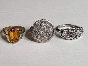 lot 1351 image: Three-Ring Collection - Gold Tone, Zodiac, and Silver-Tone Band