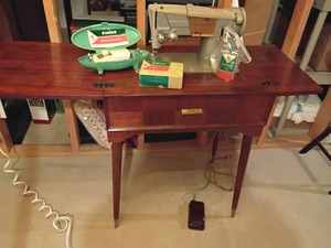 Singer Sewing Machine with Cabinet. Some Singer Extras: Buttonholer, Oil and More.  Open 31 x 48 x 17.  Closed 31 x 24 x 17.  Located in Basement