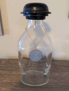 lot 863 image: Glass Measure Bottle with Black Bakelite Cap