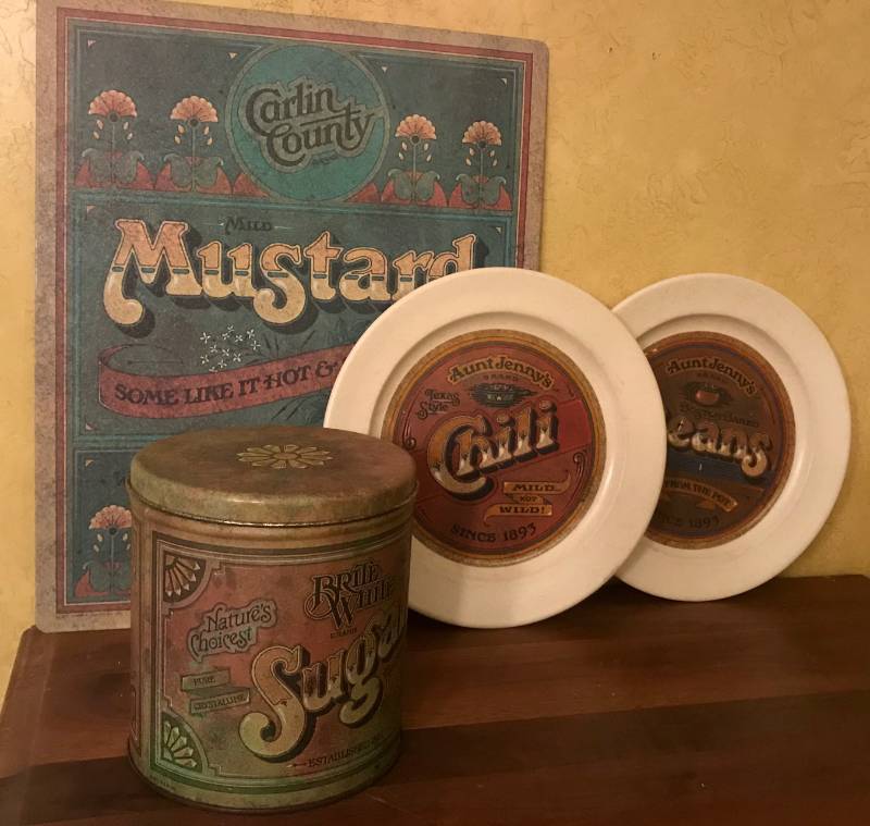 lot 2375 image: Carlin County Mustard counter mat, Aunt Jennys Plates, and Brite White Sugar Tin