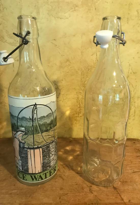 lot 2528 image: 12 Set of 2 Glass Water Bottles with flip tops (bail closure)--one with image of girl at a well