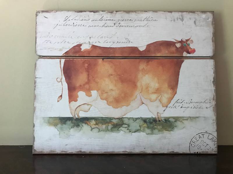 lot 2805 image: Folklore Cow print on wood planks--Wall Decor