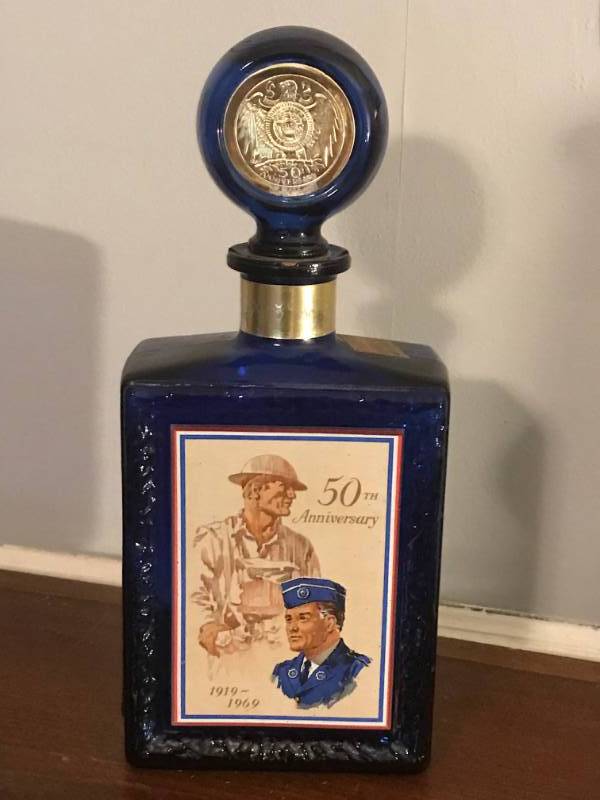 lot 2811 image: American Legion 50th Anniversary Cobalt Blue Decanter from the J.W. Dants Company, Louisville Kentucky.   Collectible Bourbon Whiskey Bottle.  Embossed Eagle on one side.