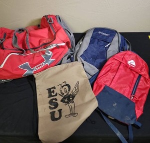 lot 477 image: Under Armour Duffle Bag, two backpacks and an ESU canvas drawstring bag. Duffle Bag would need minor cleaning inside, backpacks outside