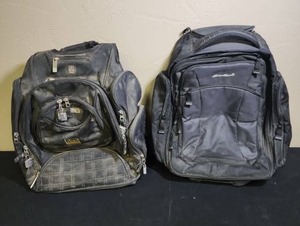 lot 489 image: Eddie Bauer Rolling Travel Backpack with extending handle (very clean inside), and an Ogio Backpack - both have loose dirt on the outside (Ogio has heavy loose dirt but should come clean with proper cleaning)