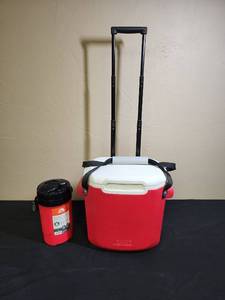 lot 494 image: Coleman Rolling Cooler with Wheel Handle and Water Jug Set - the rolling cooler has an additional carry handle that has been added to it