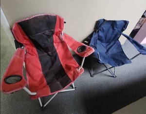 lot 496 image: 2 Folding Camping Chairs with Cup Holders - blue one has a bag.  Red one has velcro closures on back - both need a wash down but otherwise good condition
