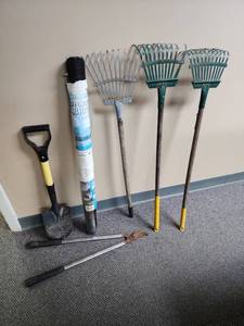 lot 517 image: Garden Tool Set with Landscape Fabric - 3 short small leaf rakes, a small shovel, and a pair of loppers (loppers have heavy patina on the head)